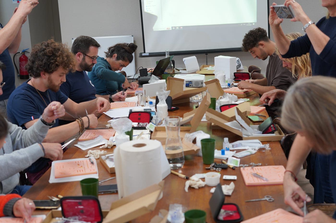Session de formation Coro — groupe de participants pratiquant des gestes médicaux autour d'une grande table